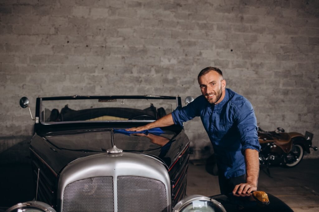 A man takes care of a retro car in the garage
